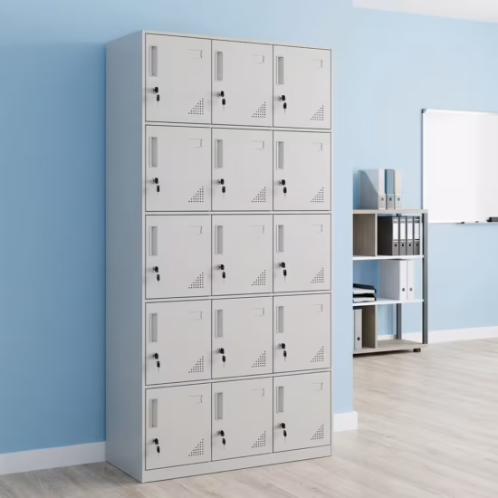 Premium 15 Locker Office Steel Cabinet in a professional light grey powder-coated steel finish, showcasing a 3x5 grid layout of fifteen closed locker doors with recessed handles, cylinder locks with keys inserted, name card frames, and stamped bottom ventilation patterns, standing flat on smooth light wood flooring against a textured grey wall.