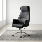 High Back Executive Office Seat featuring smooth black upholstery, a high tapered backrest, integrated padded headrest, curved armrests, and a polished metallic-toned five-star base with casters.