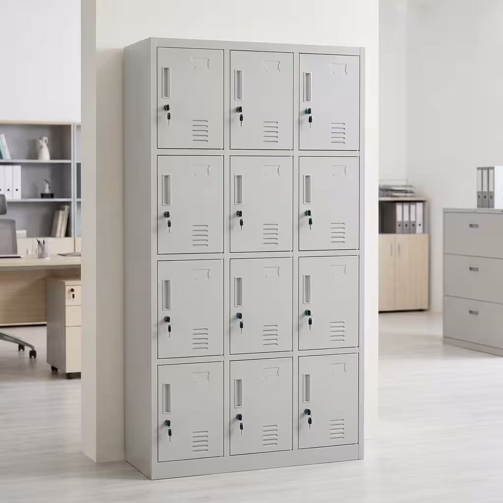 Premium 15 Locker Office Steel Cabinet in a professional light grey powder-coated steel finish, showcasing a 3x5 grid layout of fifteen closed locker doors with recessed handles, cylinder locks with keys inserted, name card frames, and stamped bottom ventilation patterns, standing flat on smooth light wood flooring against a textured grey wall.