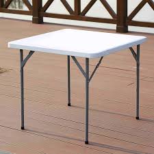 Folding Plastic Table with a square white plastic tabletop, rounded corners, slim grey metallic-toned legs, pivoting locking braces, and black protective feet caps.