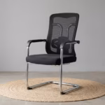 Modern black Ergonomic Mesh Guest Office Seat by TBL Furniture, featuring a breathable mesh backrest, integrated armrests, and a black steel sled base, isolated against a studio backdrop.