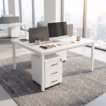 Modern White Office Workstation configured for two users face-to-face, featuring an integrated gray acoustic divider screen, laptops, and rolling 3-drawer storage units on a tan rug.