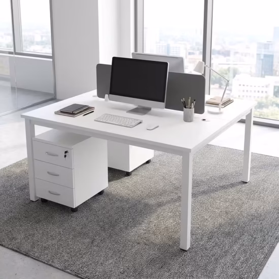 Modern White Office Workstation configured for two users face-to-face, featuring an integrated gray acoustic divider screen, laptops, and rolling 3-drawer storage units on a tan rug.
