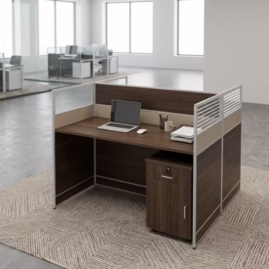 Premium 2-Way Modular Office Workstation in a deep espresso woodgrain finish, showing a private individual cubicle equipped with a silver laptop, writing utensils, a ceramic mug, and a matching lockable under-desk mobile filing cabinet, resting on a textured geometric area rug inside a modern open-plan office.