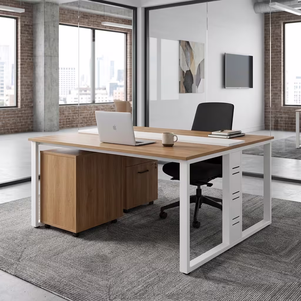 Premium 2-Way Modular Office Workstation featuring two back-to-back light woodgrain desktops, a central white privacy strip, white steel loop base legs, an integrated woodgrain drawer pedestal with a key lock, displaying a keyboard, a laptop, and a desk lamp on a geometric grey carpet.