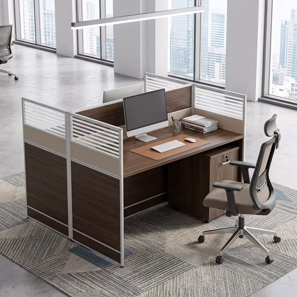 Premium 2-Way Modular Office Workstation in a deep espresso woodgrain finish, showing a private individual cubicle equipped with a silver laptop, writing utensils, a ceramic mug, and a matching lockable under-desk mobile filing cabinet, resting on a textured geometric area rug inside a modern open-plan office.