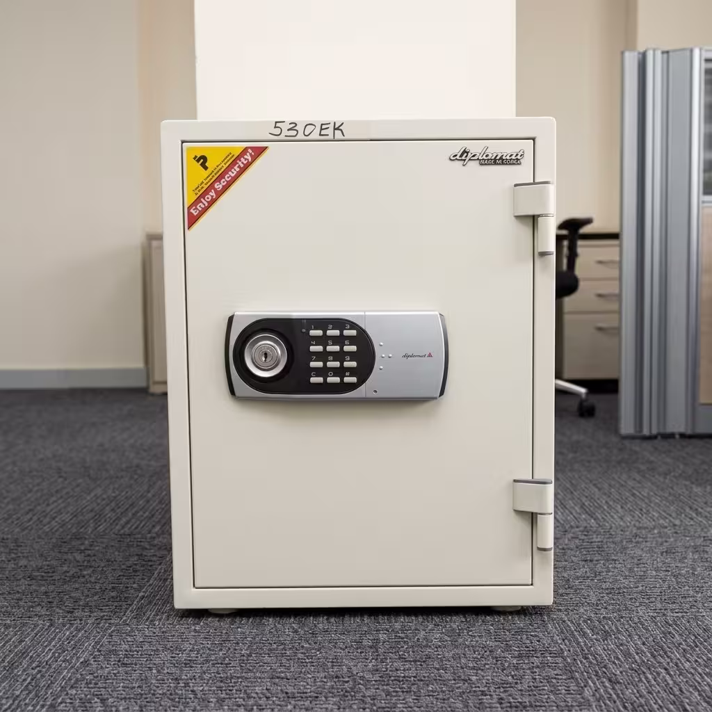 Premium Diplomat 530EK Digital Fire Safe Box in a clean off-white finish, featuring a central gray digital keypad panel with a manual key lock core, standing on a textured grey office carpet.