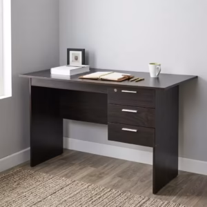 Premium 1.2M Wooden Custom Office/Home Desk in a dark espresso woodgrain finish, showcasing a flat rectangular tabletop supporting an open notebook and book, an integrated 3-drawer storage pedestal with a top key lock and silver bar handles, standing on wood-paneled flooring next to a textured beige rug