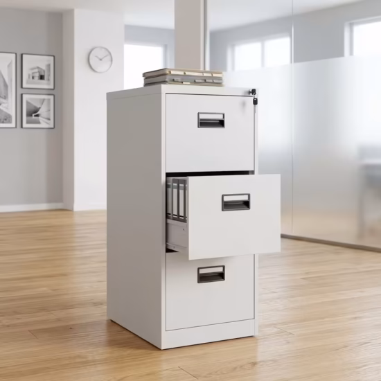 Premium 3-Drawer Cabinet With Single-Key in a professional light gray powder-coated steel finish, showing all three drawers staggered open to reveal legal hanging file tabs, complete with a key inserted in the top lock core, a stapler, and a tape dispenser on top, resting on large gray floor tiles in a glass-partitioned modern office.