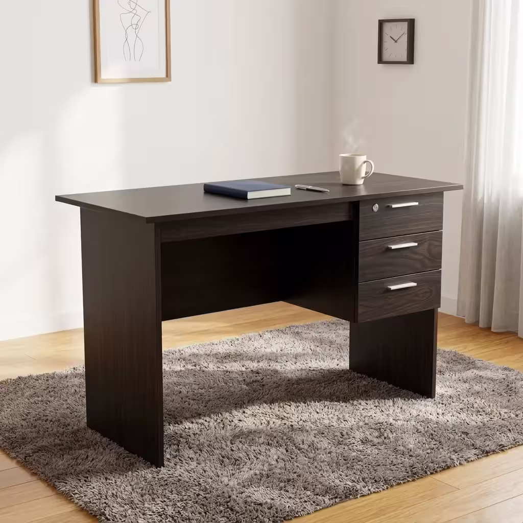 Premium 1.2M Wooden Custom Office/Home Desk in a dark espresso woodgrain finish, showcasing a flat rectangular tabletop supporting an open notebook and book, an integrated 3-drawer storage pedestal with a top key lock and silver bar handles, standing on wood-paneled flooring next to a textured beige rug