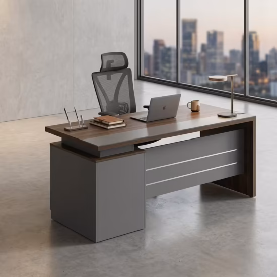 Premium 1.2M Executive Modern Wooden Office Desk in a dark walnut woodgrain finish, featuring a matte charcoal grey front modesty panel with three horizontal silver accent lines, an integrated left-side storage pedestal cabinet, a desktop supporting a modern clock, pen organizer, notebook, mug, and laptop on a polished white tile floor.