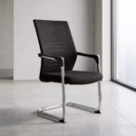 Premium Black Mesh Cantilever Visitor Chair featuring a black mesh high backrest, a thick fabric upholstered seat cushion, sleek chrome armrests with black top caps, and a reflective chrome continuous sled frame, standing on a polished concrete floor.