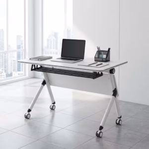 Premium 1.2M Foldable Training Office Table with a smooth white top, front black privacy baffle, and a white metal frame on lockable caster wheels, shown in a modern classroom.