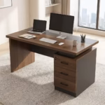 Premium 1.4M Modern Office Desk With Drawers in a rich walnut woodgrain finish, showing an open laptop and a lockable three-drawer side pedestal in a bright office study.