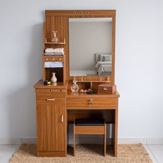 Premium Wooden Dressing Table With Storage in a rich natural oak finish, featuring an integrated center vanity mirror, multi-tier side display shelves with towels, a lockable main drawer, a lower cabinet door, and a matching slide-in cushioned vanity stool on a woven area rug.