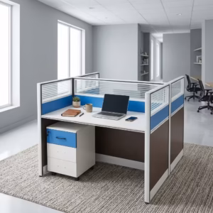 Premium 2-Way Workstation With Mobile Pedestal in a white and dark grey finish, displaying a back-to-back cubicle layout with a sleek laptop, writing utensils, a ceramic mug, electric blue accents, and an integrated lockable under-desk mobile filing cabinet resting on a light grey carpet.
