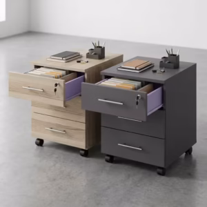 Two premium 3-Drawer Lockable Mobile Pedestals placed side by side on a polished grey concrete floor, showing one finished in a light oak woodgrain and the other in a matte graphite grey, each featuring an open top drawer with a key inserted, revealing a lavender purple inner lining and folder files.