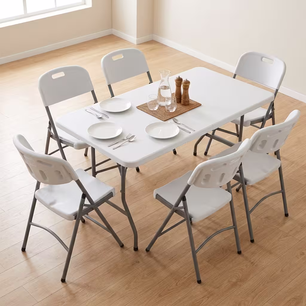 Premium Foldable Table & Chair Dining Set featuring a rectangular white plastic folding tabletop, supported by a heavy-duty powder-coated gray steel frame, surrounded by six matching white plastic folding chairs with integrated carrying handles on a light wood floor.