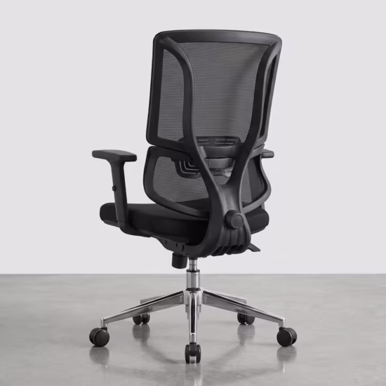 Premium mid-back Office Chair With Lumbar Support featuring a black open-mesh backrest, adjustable T-shaped armrests, a thick fabric seat cushion, and a reflective polished chrome star base with rolling wheels, standing on a polished concrete floor.