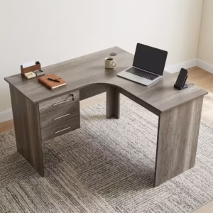 Premium 1.2M Curved Office Desk With Drawers in a warm oak woodgrain finish, showcasing a flat rectangular left-hand curved tabletop supporting a desktop computer monitor, keyboard, mouse, modern desk lamp, and a ceramic mug, with an integrated storage drawer pedestal showing a key lock, resting on a textured light tan area rug.
