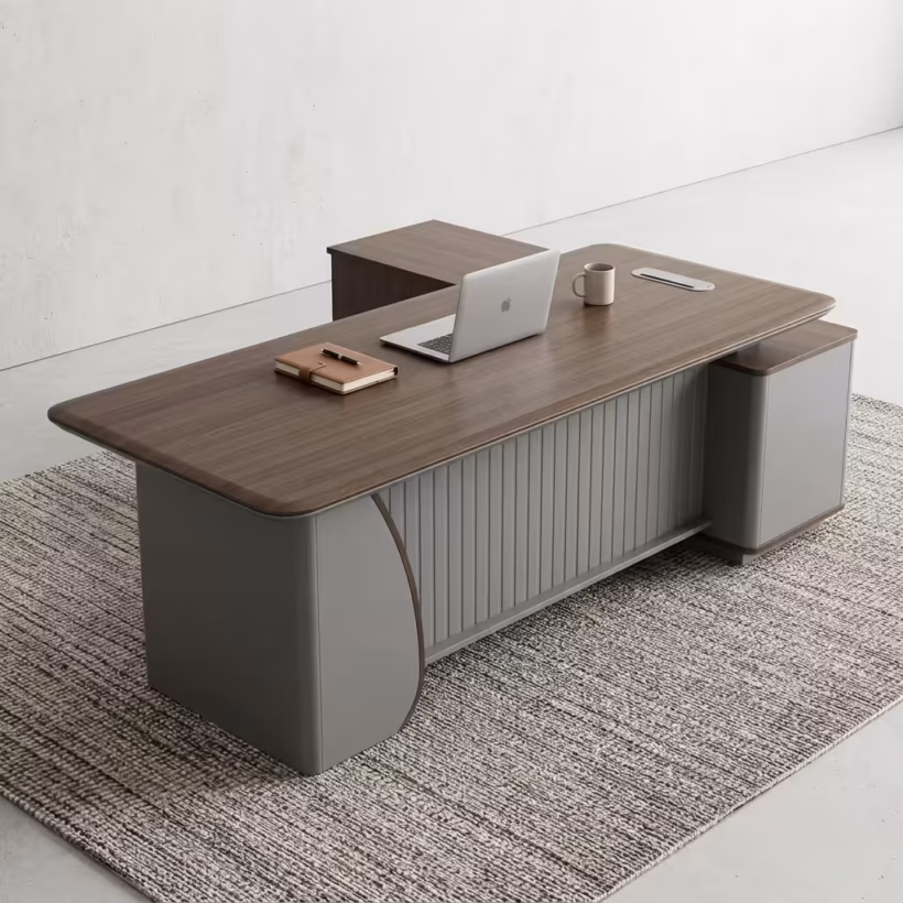 Premium 1.8M Executive Director's Office Desk in a dark charcoal-brown woodgrain finish, featuring a vertical matte grey fluted slatted front modesty panel, an integrated left-side return storage console, a right-side drawer block pedestal, a desktop supporting an open silver laptop, a leather notebook, and a ceramic mug, resting on a textured striped grey area rug.