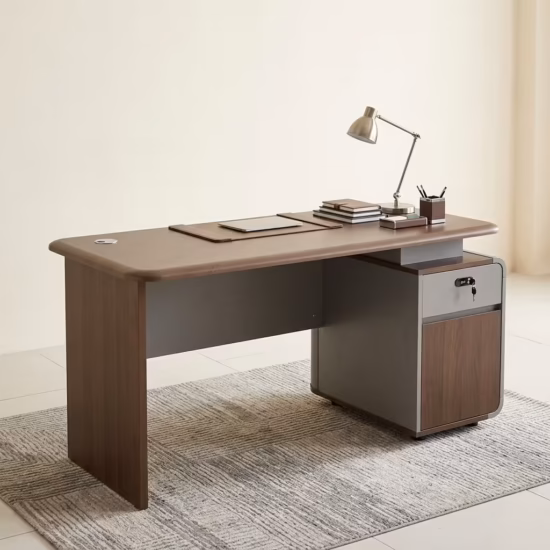 Premium 1.4M Modern Office Desk in a dark walnut woodgrain finish, featuring a built-in brown leather desk blotter mat supporting a closed tablet, a desktop holding a classic table lamp, a pen holder set, and stacked notebooks, with an integrated matte grey and wood side return storage console showing a key lock, resting on a textured striped grey area rug.