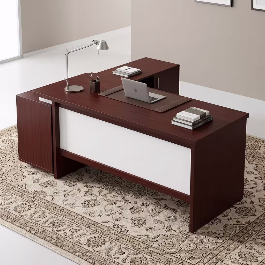 Premium 1.8M Custom Office Desk With Mobile Extension in a deep cherry-mahogany woodgrain finish, featuring an off-white front modesty panel, an integrated left-side storage console, an attached side return cabinet supporting an open laptop computer on a dark brown leather desk blotter mat, a classic silver articulating arm desk lamp, and stacked books, resting on an ornate patterned traditional area rug.