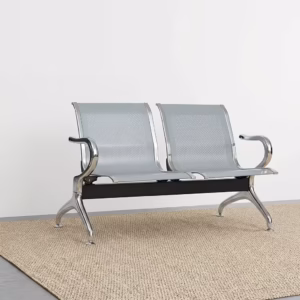 Premium 2-Link Steel Office Waiting Bench featuring two linked silver metallic chairs with perforated mesh patterns, integrated curved polished chrome side armrests, and sturdy silver metal arching legs with adjustable leveling glides, standing on a textured tan woven rug inside a modern corporate reception room.