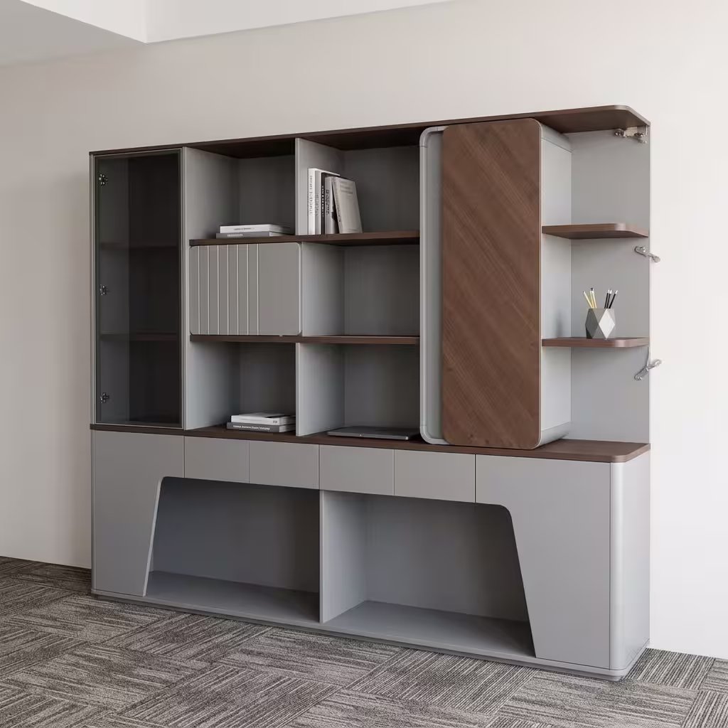 Premium Executive Modern Office Wooden Cabinet in a dual-tone matte grey and walnut woodgrain finish, showcasing a tinted smoked-glass case on the left, open book shelves with a grey ribbed sliding door, a vertical rounded wood panel block on the right next to open side shelving with a pen holder, and lower push-open drawers above a geometric open base cutout, standing on grey textured office carpet tiles.