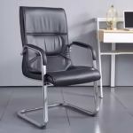 Premium PU Leather Office Visitor Chair featuring a black leatherette mid-backrest with horizontal pleat lines, integrated chrome armrests with matching black top pads, and a highly reflective continuous chrome steel cantilever sled frame, standing on large grey tile flooring next to a small wooden desk.