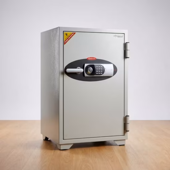 Premium 122Kg Diplomat Fireproof Safe in a durable textured off-white powder-coated steel finish, showing a thick front door fitted with a horizontal silver pull-handle, a black-paneled digital electronic keypad, a manual key override slot, and visible heavy-duty side hinges, standing flat on smooth polished hardwood laminate flooring against an off-white studio background.