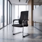 Premium Ergonomic Mesh Office Visitor Chair featuring an open-airflow black mesh backrest with a vertical silver spine insert, sweeping black armrests, a plush black fabric seat cushion, and a highly reflective continuous chrome steel cantilever sled base, standing on a polished concrete floor inside a modern sunlit corporate office.