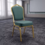 Premium Heavy Duty Green Banquet Seat featuring a crown-arched backrest and thick box seat cushion upholstered in plush teal velvet, supported by an industrial-strength metallic gold-finished steel frame, standing on a dark grey patterned carpet inside a modern seminar hall.
