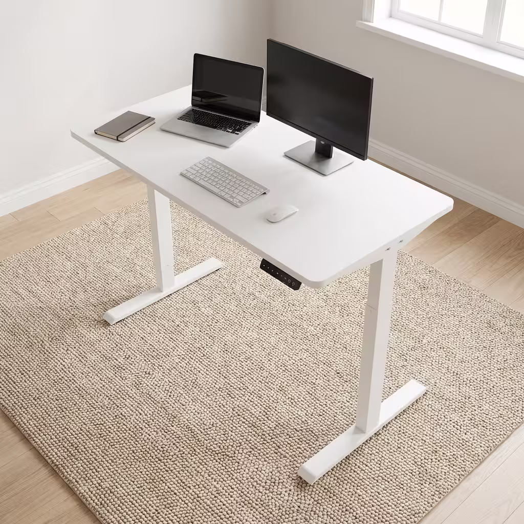 Premium 1.4M Adjustable Height Electric Table in an ultra-clean all-white finish, showcasing a spacious rectangular top panel holding an all-in-one computer screen, a silver wireless keyboard, and an optical mouse, featuring a digital keypad controller box on the front left margin, supported by a heavy-duty motorized steel T-frame lifting column base, resting on a textured woven beige area rug.