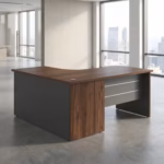 Premium 1.4M Curved Office Desk With Drawers featuring an ergonomic L-shaped corner top panel with a rich walnut woodgrain finish, supported by matte charcoal grey side panels and a front modesty shield decorated with two horizontal silver accent lines, resting on a smooth polished concrete floor in a modern glass office setting.