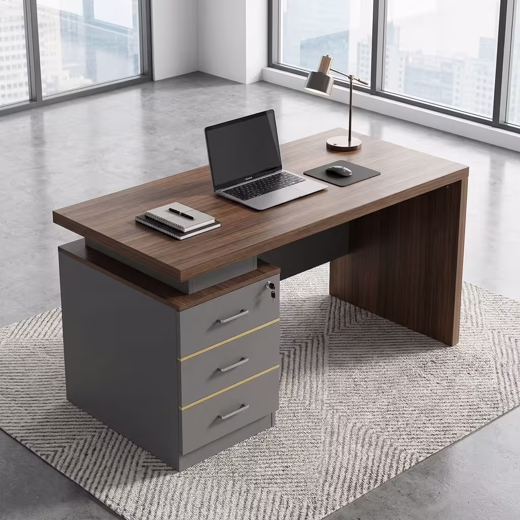 120cm Executive Desk With Lockable Drawers Premium 120cm Executive Desk With Lockable Drawers featuring a rich walnut woodgrain top panel, an integrated matte charcoal gray 3-drawer storage pedestal on the left with silver handles and gold trim, an open laptop, mouse pad, and notebooks on top, resting on a textured geometric cream area rug over a polished concrete floor.