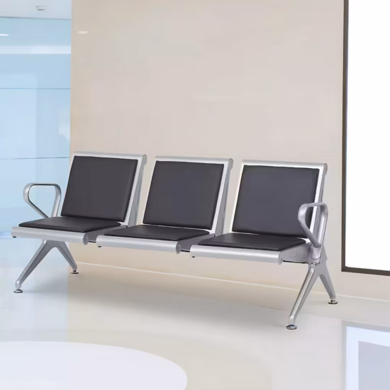 Premium 3-Seater Padded Metallic Waiting Bench featuring three linked silver metallic chairs with black padded leatherette seats and backrests, integrated curved aluminum-alloy side armrests, and sturdy silver metal triangle legs with adjustable leveling glides, standing on a reflective white floor inside a modern corporate reception room.