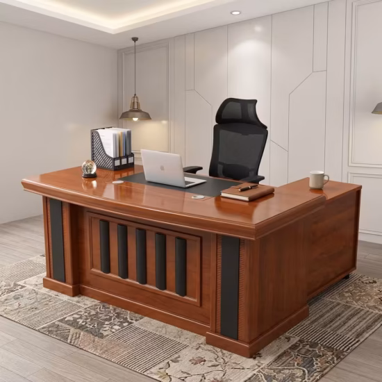 Executive 160cm L-Shaped Office Desk in a rich cherry wood finish with black leather desk padding and a decorative panel front, paired with an ergonomic chair.