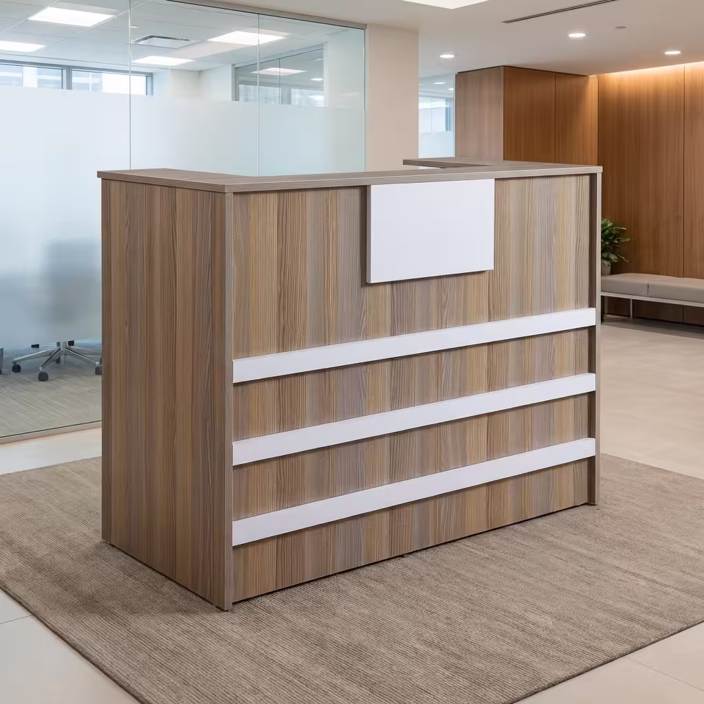 A compact Wooden 1200mm Office Reception Desk featuring vertical light brown wood grain panels accented with three horizontal white stripes and a top white display panel, resting on a beige rug in a bright lobby.