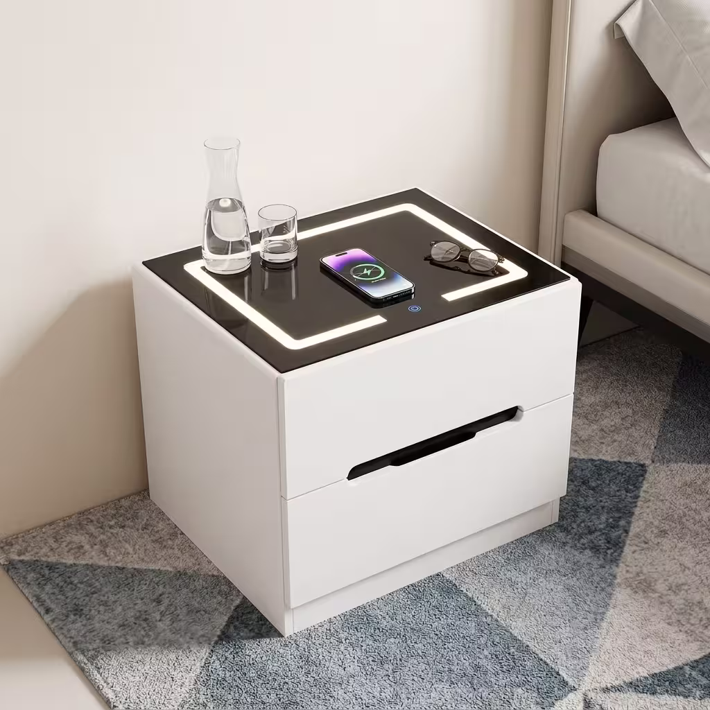 Modern white Bedside Table With Lighting featuring an integrated wireless charging top panel, warm LED border glow, and a minimalist handle less drawer design on a beige rug.